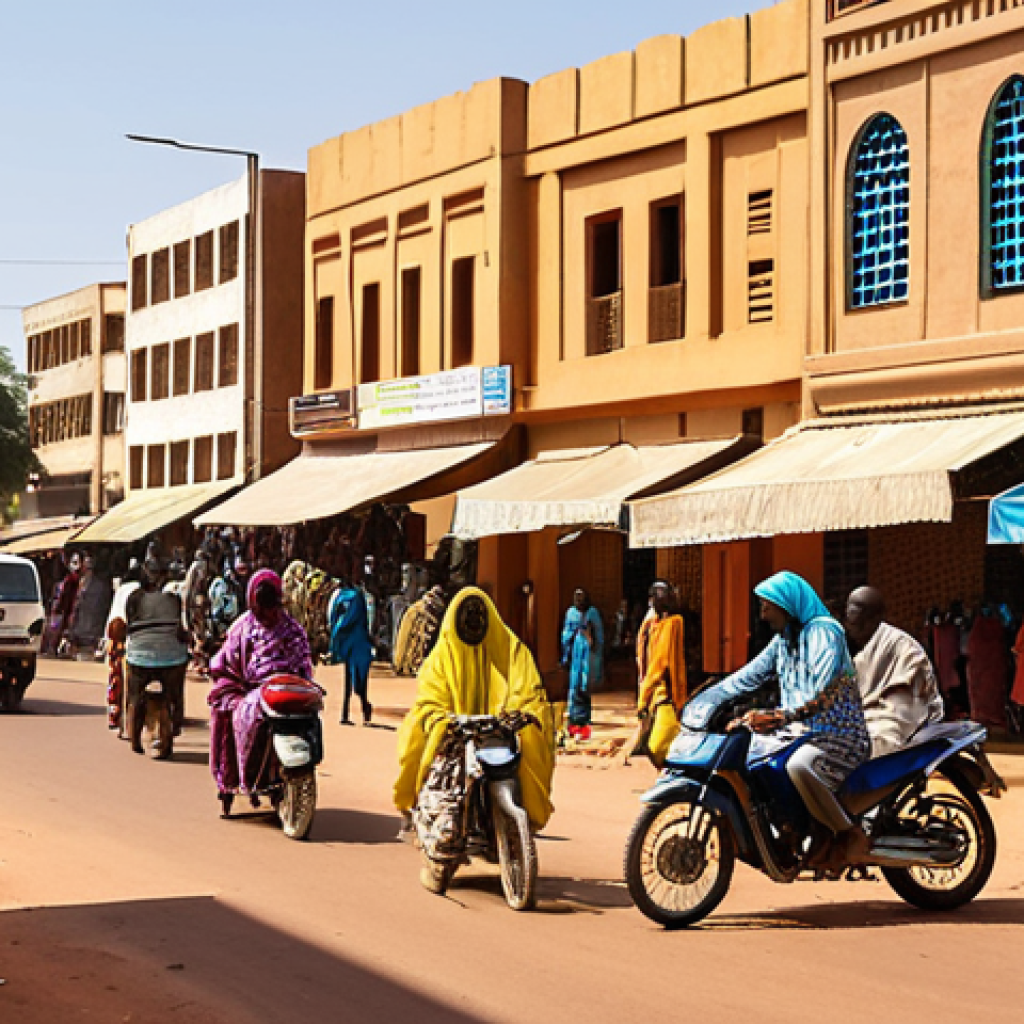 **A bustling street scene in downtown Niamey, Niger:** Capture the vibrant energy with street vendors, colorful clothing, and a mix of modern and traditional architecture. Show a busy intersection with cars, motorcycles, and pedestrians navigating the chaos. Include a mix of shadows and bright sunlight, reflecting the African climate.